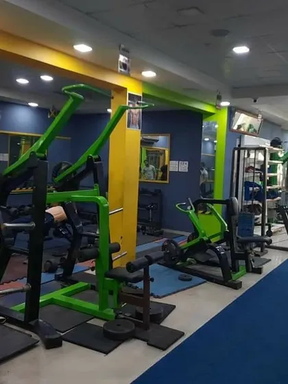 A wide view of our strength training floor, showing the lat pulldown machines and cable stations. The layout is designed to provide easy access to all equipment even during peak hours.