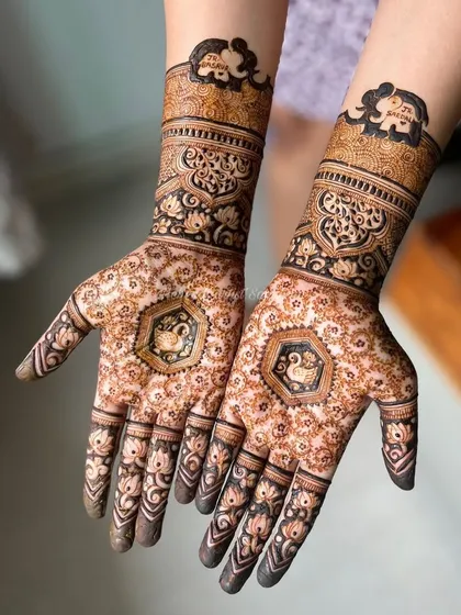 A lovely baby shower design featuring graceful swans in the palms and elephant motifs on the wrists.