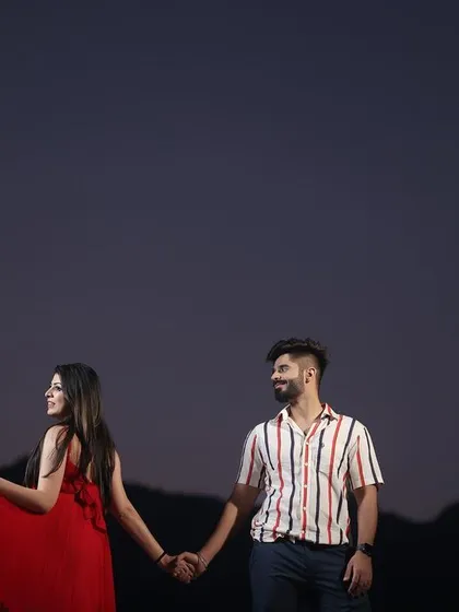 A beautiful twilight moment captured in the hills of Rishikesh. The soft, fading light creates a romantic and slightly mysterious mood, perfect for a quiet, intimate shot that focuses on the couple's connection.