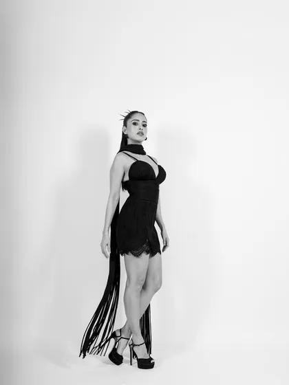 A full-length profile shot that emphasizes the subject's form and the dramatic length of the scarf.