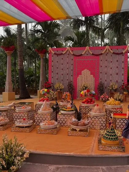 A wider view of the colorful outdoor stage, showing the surrounding palm trees.