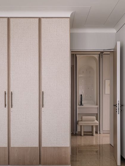 A view from the father's bedroom into the prayer area, showing the continuity of design through fabric-clad wardrobes and consistent architectural details.