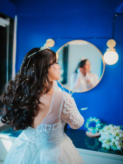 The bride gets ready in front of a mirror, a classic and beautiful shot that captures the final moments of her preparation.