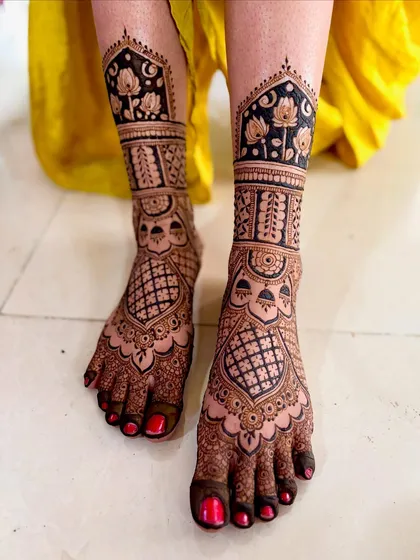 Your bridal look isn't complete without beautiful mehendi on your feet. This design features full coverage with intricate jaali work and delicate lotus flowers, ensuring you look stunning from head to toe on your big day.