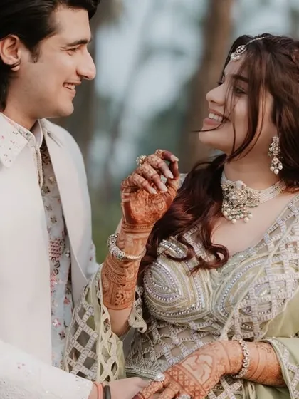 A candid shot of a happy couple, with the bride's beautiful mehndi on display. Her smile says it all.