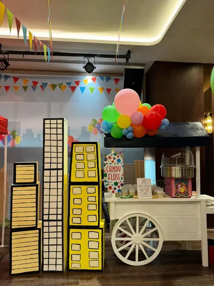 A Central Park-themed first birthday featuring a stunning carousel centerpiece, a candy floss cart, and a large pastel-colored soft play area for endless fun.
