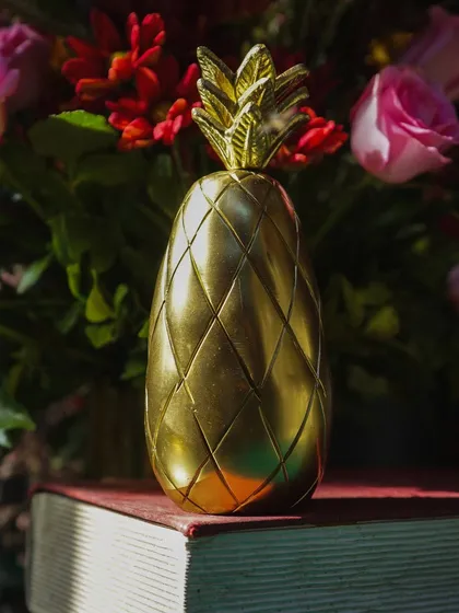 For this mehndi, we used rich red florals and unique decor pieces like this brass pineapple to create a warm and inviting atmosphere. The details reflect a blend of tradition and modern style.