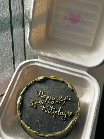A chic black and gold bento cake for a 35th birthday. The torn edge effect with gold detailing gives it a modern and sophisticated look.