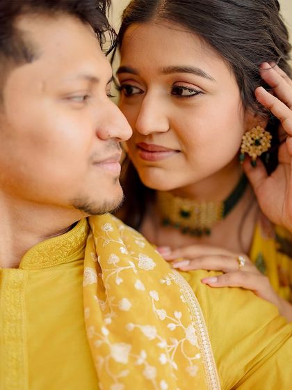 An intimate close-up, capturing the tender connection between the couple during a quiet moment at their Haldi function.