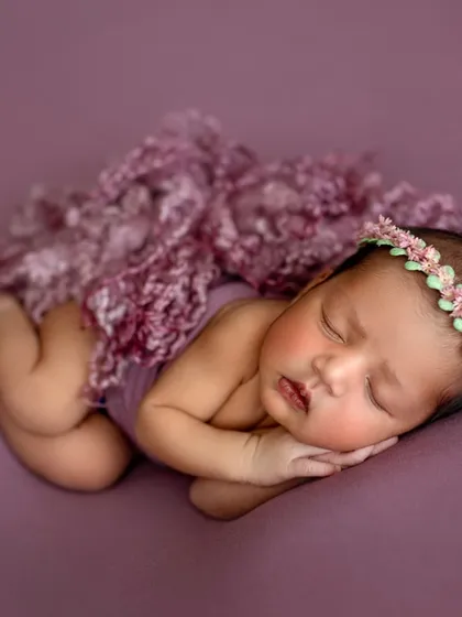 This image showcases a classic newborn pose on a simple, solid-colored fabric. We focus on getting the baby's position just right to highlight their tiny features and peaceful expression.