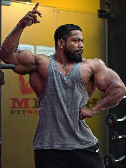 No victory without sacrifice. A classic pose showing the V-taper and arm development.