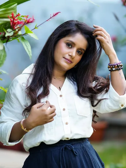 An elegant outdoor portrait of a woman in a casual outfit, looking thoughtful and poised.
