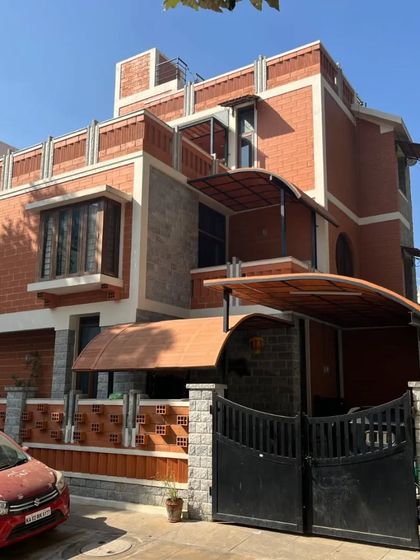 This home features a complex facade with multiple rooflines, bay windows, and a mix of stone and brick, creating a visually rich and dynamic exterior.