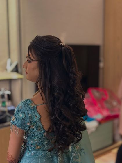 A side profile of the half-up ponytail, showing the height at the crown and the beautiful cascade of curls. This angle demonstrates how the style adds length and elegance.