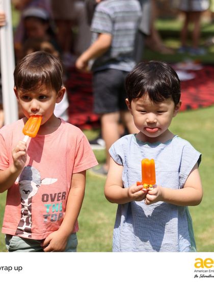 Two Pre-K students enjoy a well-deserved popsicle break during their end-of-year celebration. Simple joys and shared treats are part of what makes our school community feel like a family.