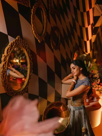 The bride surrounded by mirrors in the checkered room. This artistic shot plays with reflections and patterns, adding a layer of surrealism to the Wonderland theme.