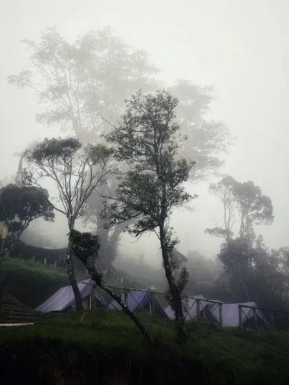 The campsite enveloped in thick fog, creating a moody and atmospheric scene.