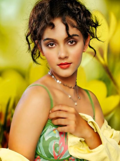 A fresh and vibrant portrait. The projected background of yellow flowers creates a cheerful and sunny atmosphere, while the soft lighting captures the model's innocent and engaging expression.