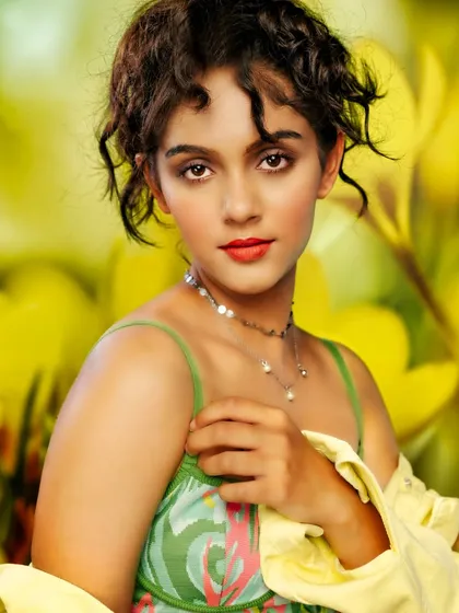 A fresh and vibrant portrait. The projected background of yellow flowers creates a cheerful and sunny atmosphere, while the soft lighting captures the model's innocent and engaging expression.