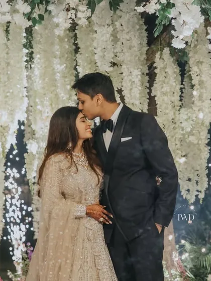 A close-up of the couple under the blossoming tree, surrounded by cold pyrotechnics. We love creating these picture-perfect moments that blend our decor with the couple's celebration.