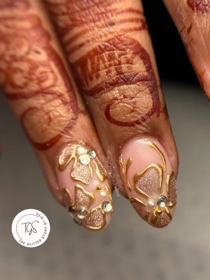 A close-up view of the detailed 3D gold work and pearl accents on this bridal nail set. Every element is carefully placed by hand.