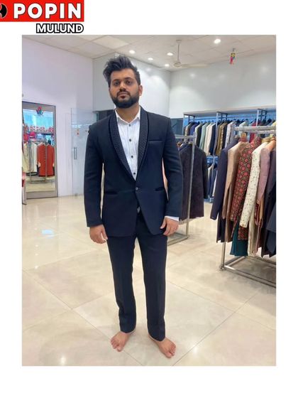 A client trying on a classic black tuxedo in my store. The fit is key, and I make sure every rental is altered to look like it was made just for you.