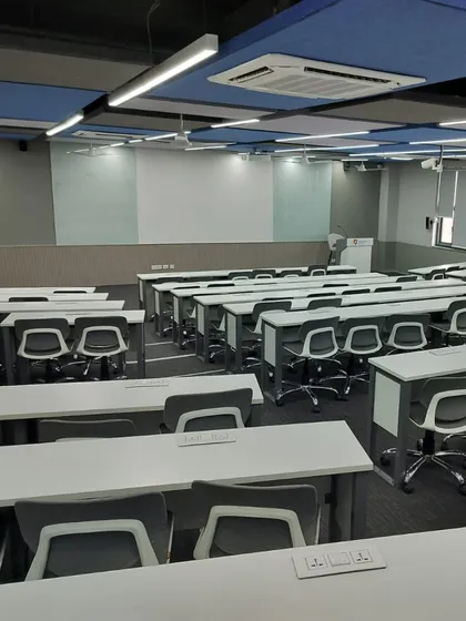 A modern classroom at Rishihood University with flexible, wheeled seating and acoustic ceiling panels. The design allows for easy reconfiguration, supporting various teaching styles from traditional lectures to collaborative group work.