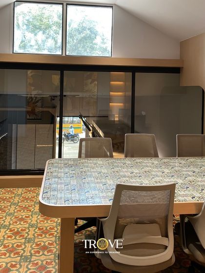 Our consultation areas are designed to be functional and inspiring. This meeting table itself is tiled with a classic pattern, surrounded by vibrant floor tiles, showing how different designs can work together in a single space.