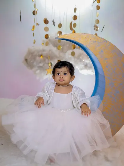 Bring your celestial dreams to life with our moon and stars backdrop. This fantasy set, complete with fluffy clouds, a crescent moon seat, and hanging golden stars, is perfect for creating magical, serene portraits of your little one.