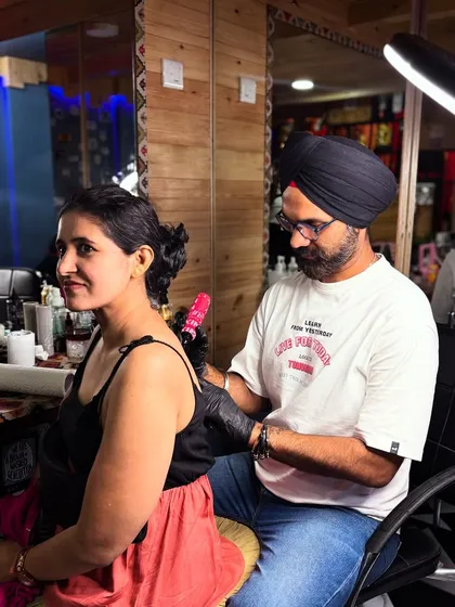 A candid shot of a tattoo session in progress. The studio is designed to be a comfortable and inspiring space.