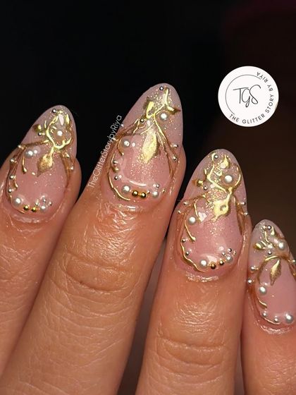A macro shot of the detailed 3D gold leaf and pearl work on a bridal nail. You can see the precision and care that goes into creating these miniature works of art.