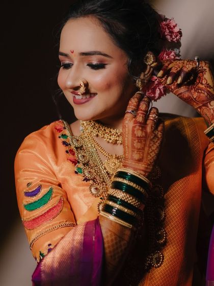 A candid moment of the bride adjusting her floral hair accessory, her smile radiating pure happiness and excitement.