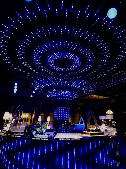 I transform Sangeet nights into immersive experiences. Here, a custom-designed ceiling of concentric LED rings creates a mesmerizing starry sky effect over the central bar, setting a futuristic and high-energy techno vibe for the party.