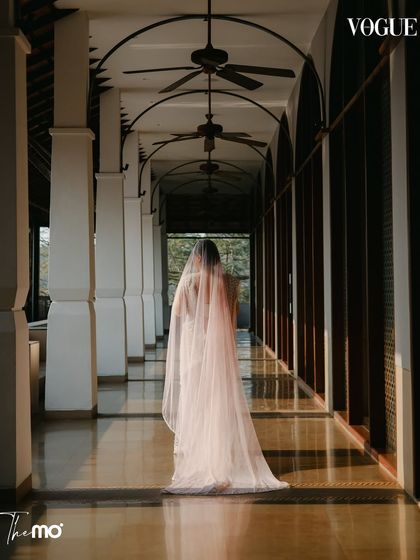 A serene portrait of the bride walking through a corridor at the Hilton Goa. Featured in Vogue India, this image uses the architecture and light to create a timeless and elegant bridal shot.