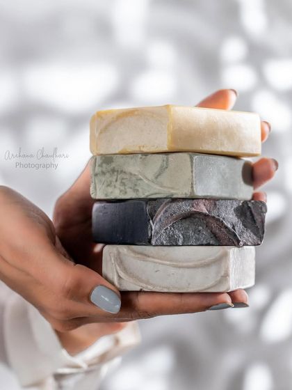 A lifestyle shot featuring a stack of handmade soaps held by a model. This type of image helps customers visualize the product's texture and size.