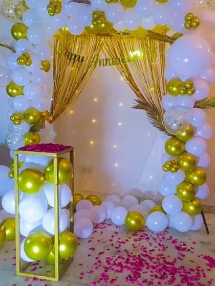 This image showcases the complete anniversary setup, combining the rose petal path with the shimmering gold and white backdrop.