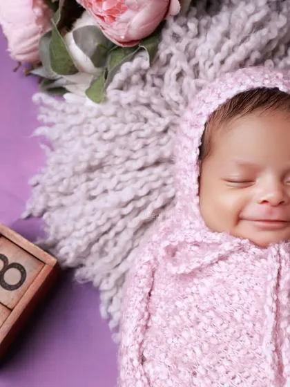 The pure, sleepy smile of a newborn is a moment to treasure. This close up captures that fleeting expression, a beautiful memory from the first few weeks of life.