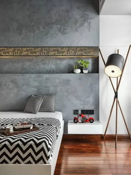 A great example of a modern bedroom using raw textures. The concrete-finish feature wall with an integrated backlit niche provides a cool, industrial backdrop for the warm wooden floors and minimalist furniture.