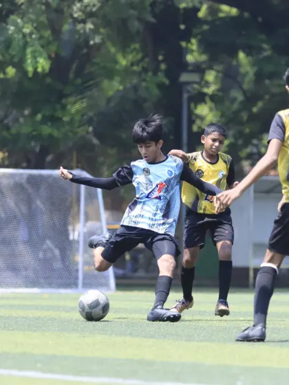 A player takes a powerful shot on goal, demonstrating the shooting practice and technique learned at the academy.