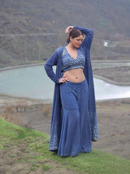 This stylish blue Indo-Western co-ord set, featuring palazzo pants, a crop top, and a matching long jacket, is perfect for a modern festive look.