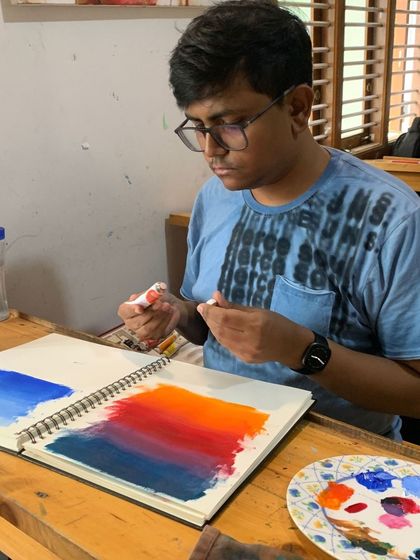 A student in our Foundation in Acrylic Painting course learns about blending colors to create a smooth gradient for a sunset background.