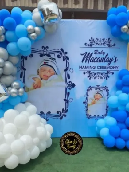 A beautiful naming ceremony for Baby Macaulay. The custom backdrop features photos of the baby, framed by a lovely blue and white balloon arrangement that looks like clouds.
