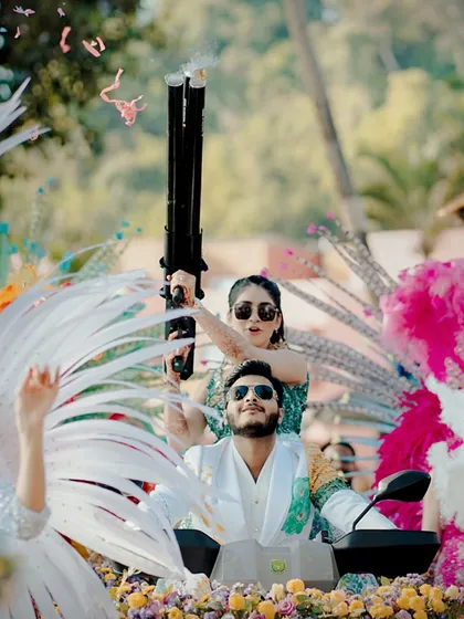 The bride takes aim with a confetti gun during their carnival entry. We love adding these playful and fun details to our events.