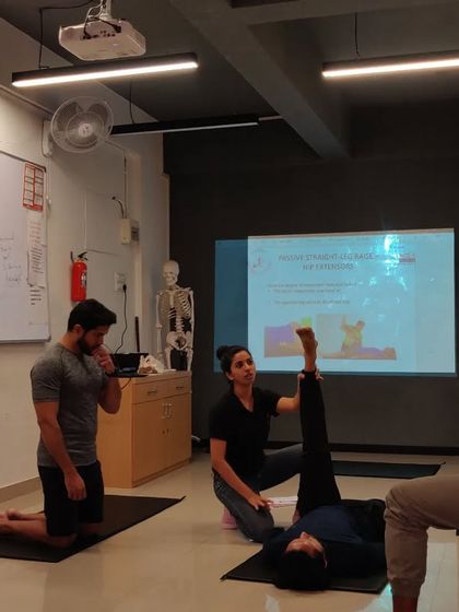 Demonstrating a hamstring flexibility assessment during a certified personal trainer course. Understanding how to assess clients is a fundamental skill for any fitness professional.