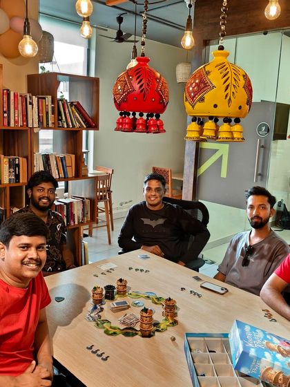 This group is setting up for a game of 'Wandering Towers' under our unique, colorful lamps. The decor adds to the fun and creative atmosphere.