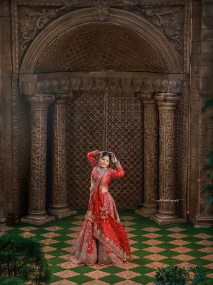A bride deserves to feel like royalty, and I use grand settings and expert posing to achieve that. This full-length portrait showcases a magnificent red bridal lehenga against the stunning architecture of Elements Bangalore, creating a truly majestic image.