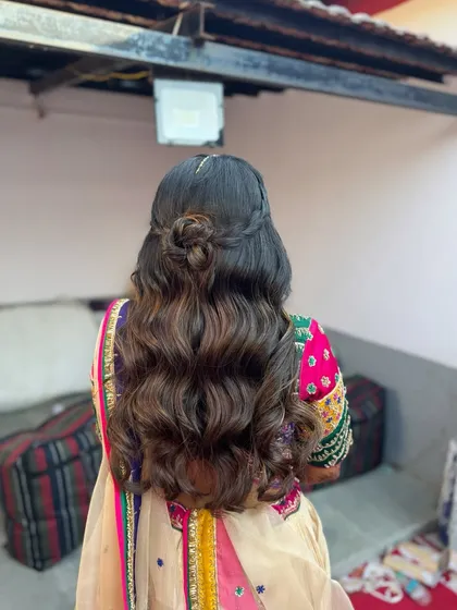 For this Haldi look, I created a boho-inspired half-updo with a small braided knot. It's a beautiful style that doesn't require any flowers or accessories to stand out.
