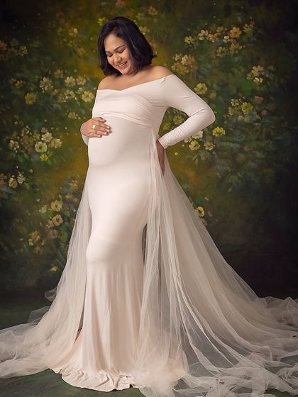 A lovely portrait against a painted floral backdrop. The off-white gown provides a beautiful contrast and the pose is full of grace.