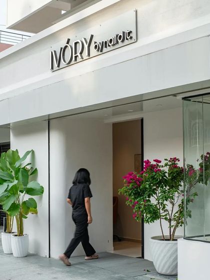 The clean, white facade of 'The Ivory' nail salon, with its simple branding, creates an elegant and inviting street presence.