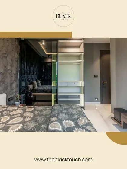 A stylish bedroom with a dark, textured wall and a glass-paneled wardrobe. The design is modern and sophisticated, creating a moody yet comfortable ambiance.